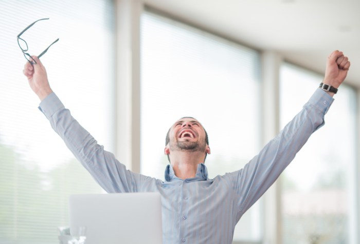 Picture of a man celebrating with his arms lifted in the air representing the happy clients that saved money by breaking their mortgage